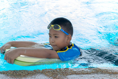 Portrait of cute boy swimming in pool