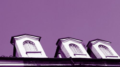 Low angle view of cross against building against sky