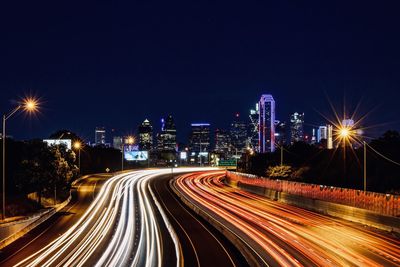 Light trails on road against sky at night