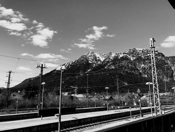 Railroad tracks by road against sky