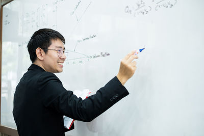 Side view of a young man holding eyeglasses