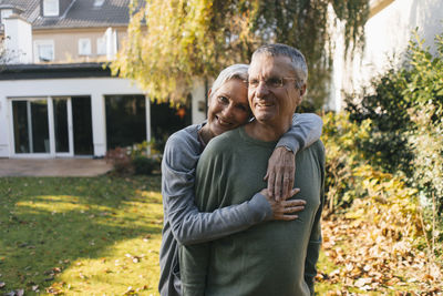 Happy affectionate senior couple hugging in garden