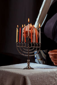 Close-up of woman igniting candles