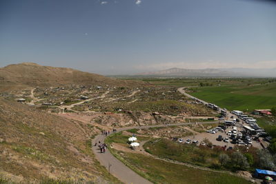 High angle view of road amidst field against sky