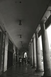 People walking in corridor of historic building