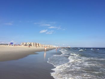 Scenic view of beach against blue sky