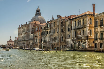 Grand canal by buildings and santa maria della salute against sky