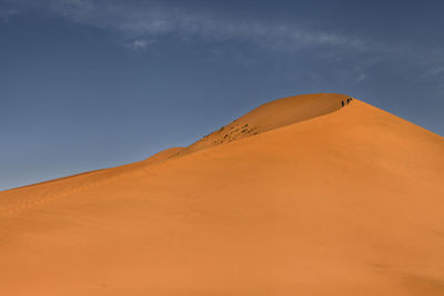 Low angle view of sand dunes against sky