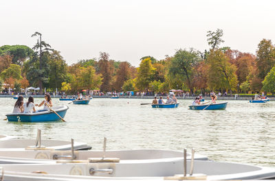 People in lake against clear sky