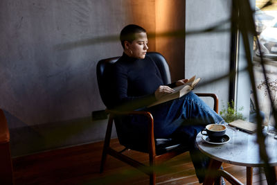 Young woman using laptop while sitting on table