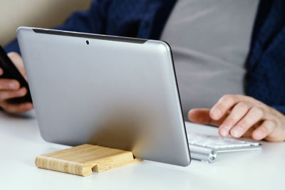 Close-up of person using laptop on table