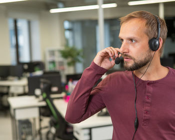 Caucasian bearded man with a headset. male call center worker.