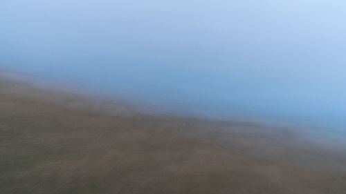 Scenic view of fog over sea against sky