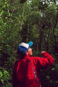 Rear view of boy standing at forest