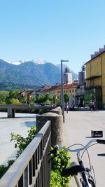 Buildings by mountains against clear sky