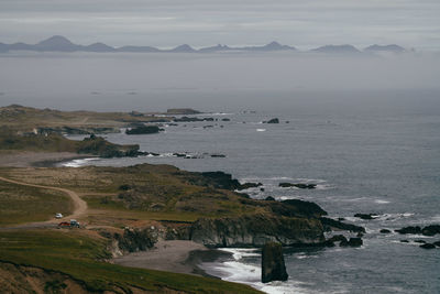 Scenic view of sea and mountains against sky