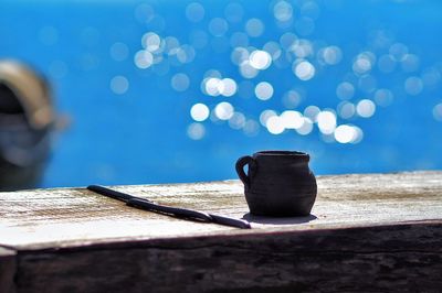 Clay jug on table during sunny day