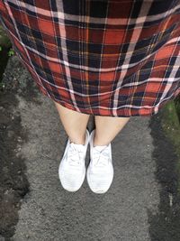 Low section of woman standing on road