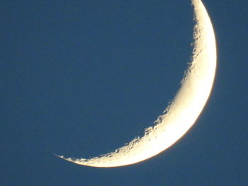 Low angle view of moon against clear blue sky