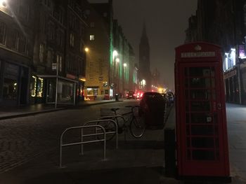 Cars on illuminated street in city at night