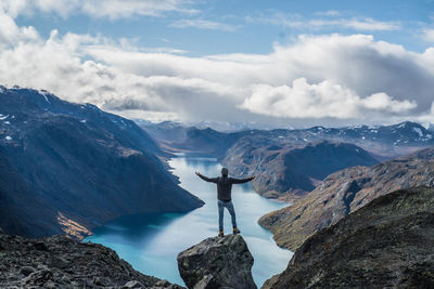 Hiker standing on rock against lake