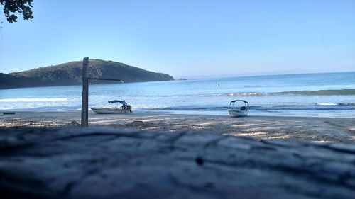 Scenic view of beach against clear blue sky