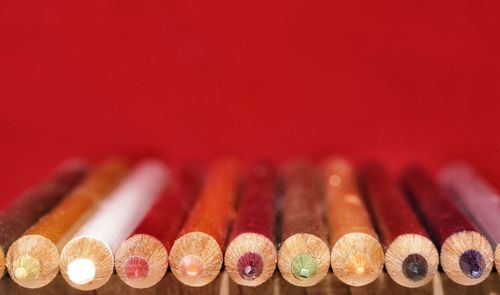 Close-up of colored pencils against red background