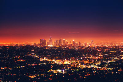 Illuminated city against sky at night