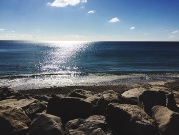 View of calm beach against blue sky