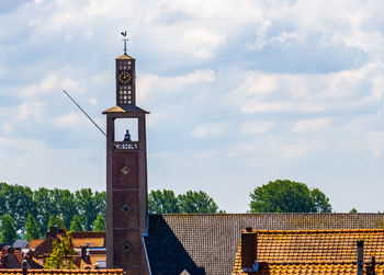 View of tower by building against sky