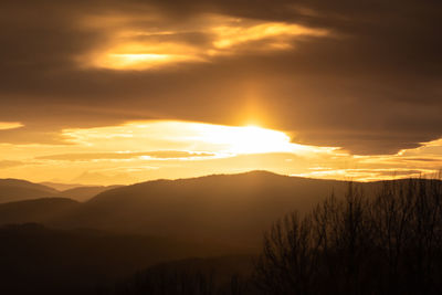 Scenic view of silhouette mountains against romantic sky at sunset