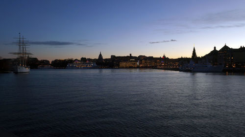 River by buildings against sky during sunset