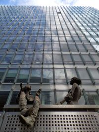 Low angle view of sculpture on city against sky