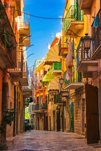 Low angle view of alley amidst buildings in city