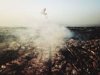 An aerial view of zejtun city in malta with the fireworks smoke in the background.