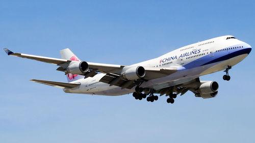 Low angle view of airplane against clear blue sky