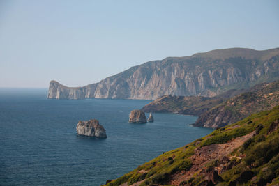 Scenic view of sea and mountains against clear sky