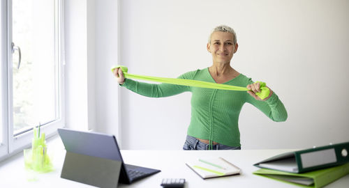 Portrait of woman using digital tablet while standing on table