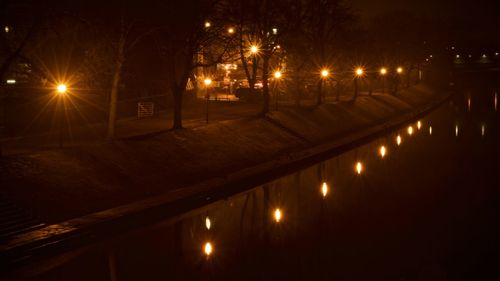 Illuminated road against sky at night