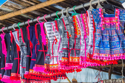 Multi colored clothes hanging in store for sale at market stall