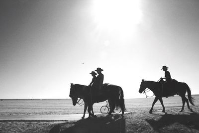 Men riding horses on landscape against sky