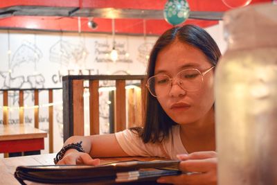 Close-up of teenage girl reading menu in restaurant