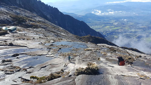 High angle view of men walking on rocky mountains