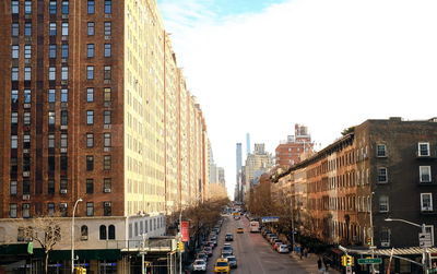 View of city street and buildings against sky