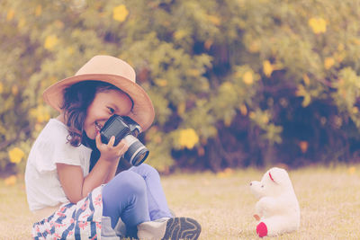 Midsection of woman photographing against sky