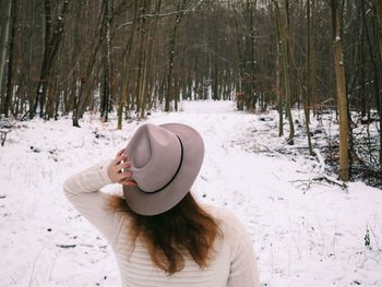 Woman wearing hat in snow covered forest