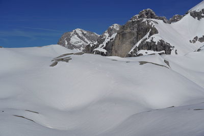 Snow covered mountain against blue sky