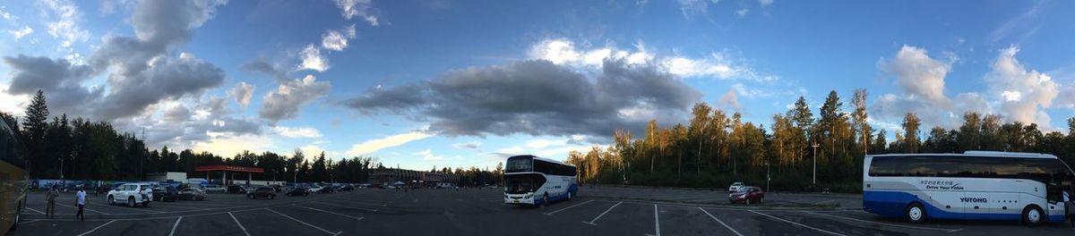 Cars on road against cloudy sky