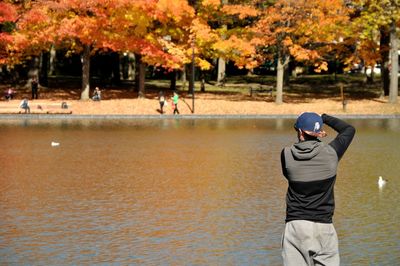 Rear view of man with arms raised in autumn