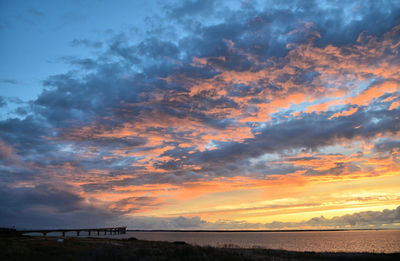 Scenic view of dramatic sky over sea during sunset